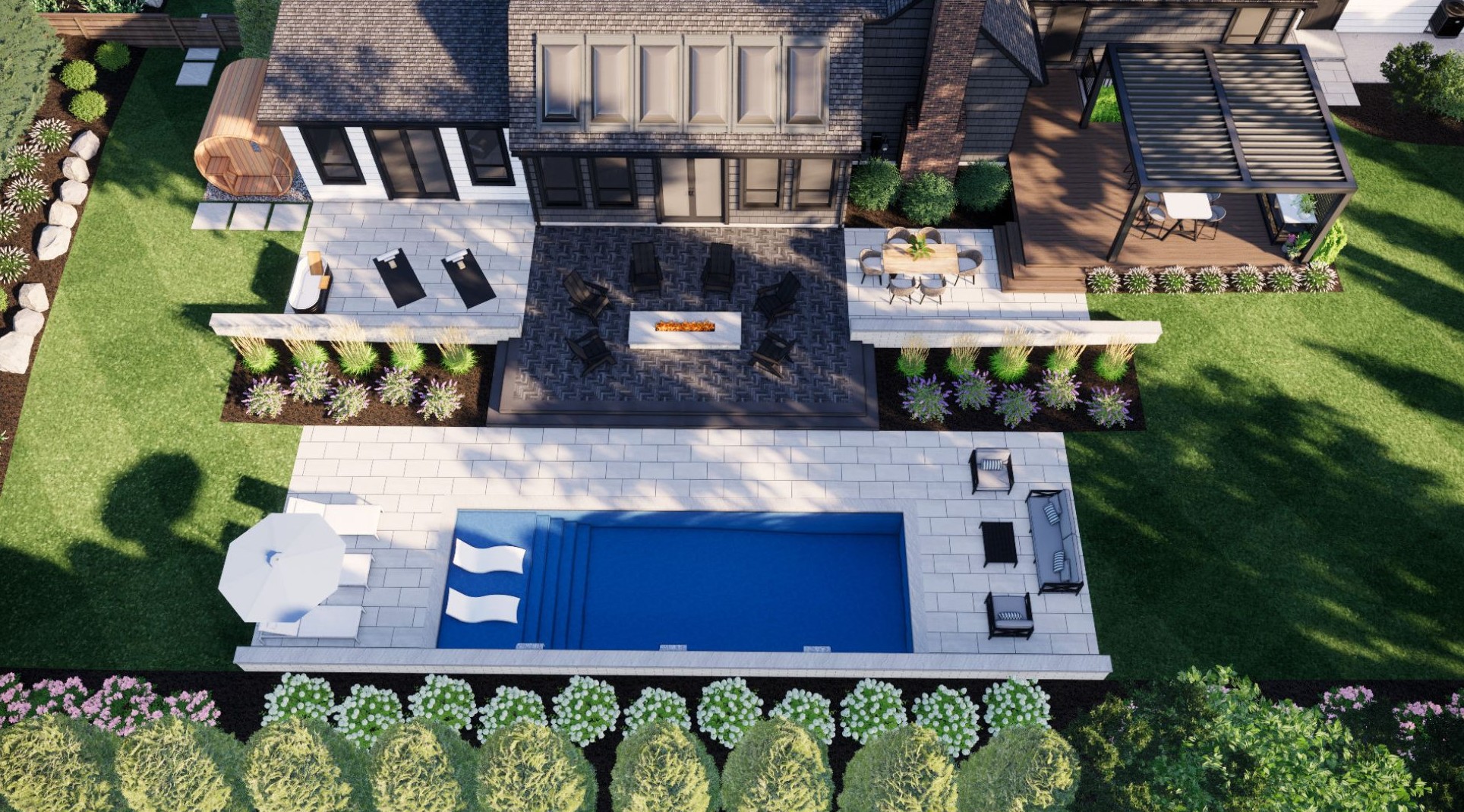 Modern backyard with a pool, patio, fire pit, and lounge chairs surrounded by lush greenery and landscaped gardens, viewed from above.