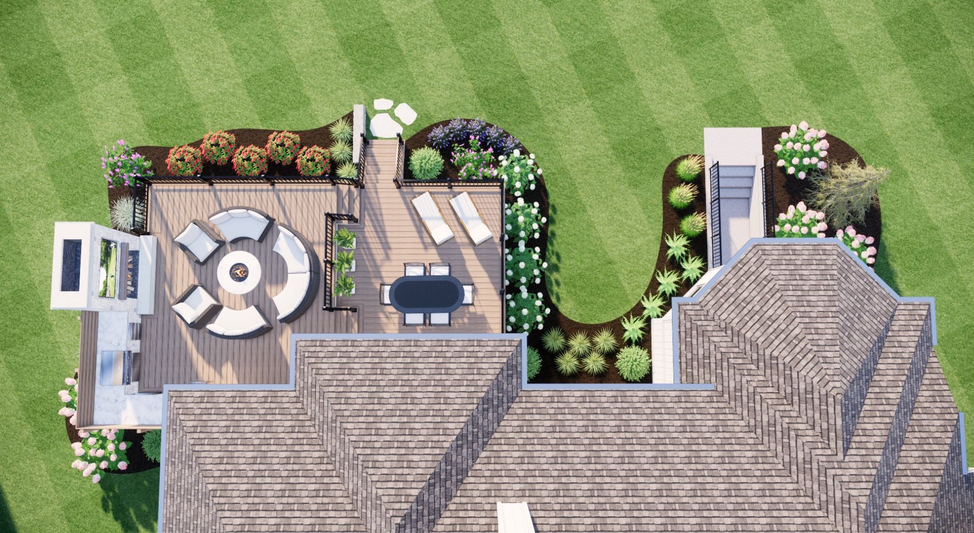 Aerial view of a landscaped backyard with a wooden deck, seating area, fire pit, and well-maintained lawn, surrounded by colorful flower beds.